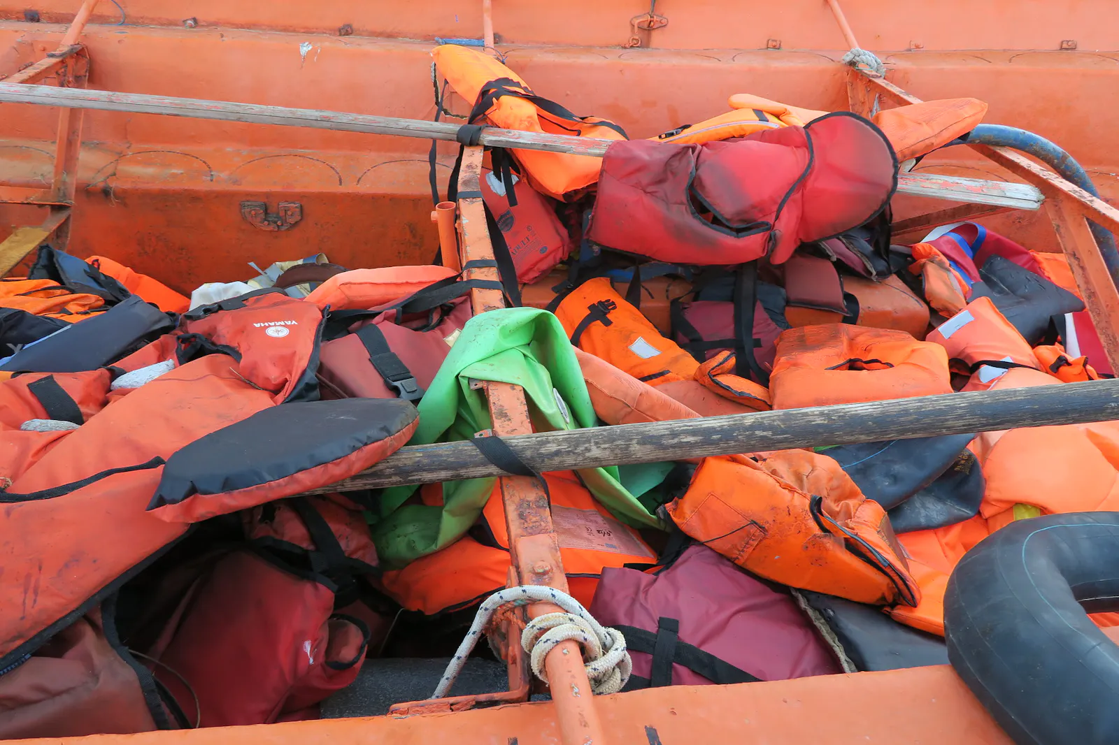 Gebrauchte und abgenutzte Schutzwesten liegen auf einem zur Flucht genutzten Schlauchboot