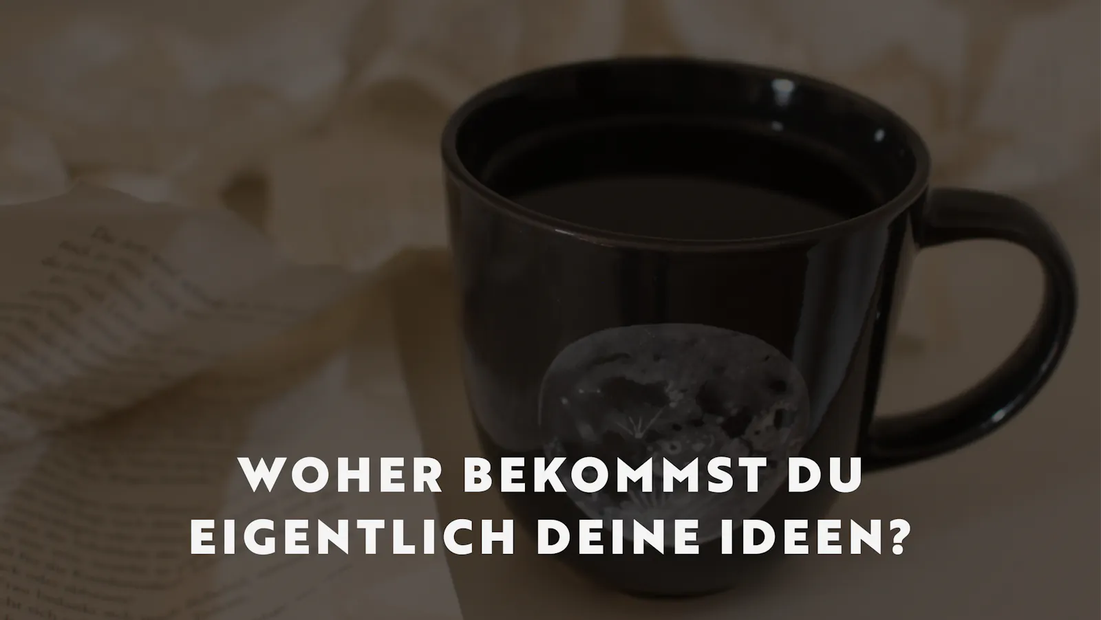 Man sieht zerknüllte Buchseiten, dazwischen steht eine dunkelgraue Tasse, gefüllt mit Tee, auf der ein Vollmond zu sehen ist. Darüber liegt die Überschrift: Woher bekommst du eigentlich deine Ideen?