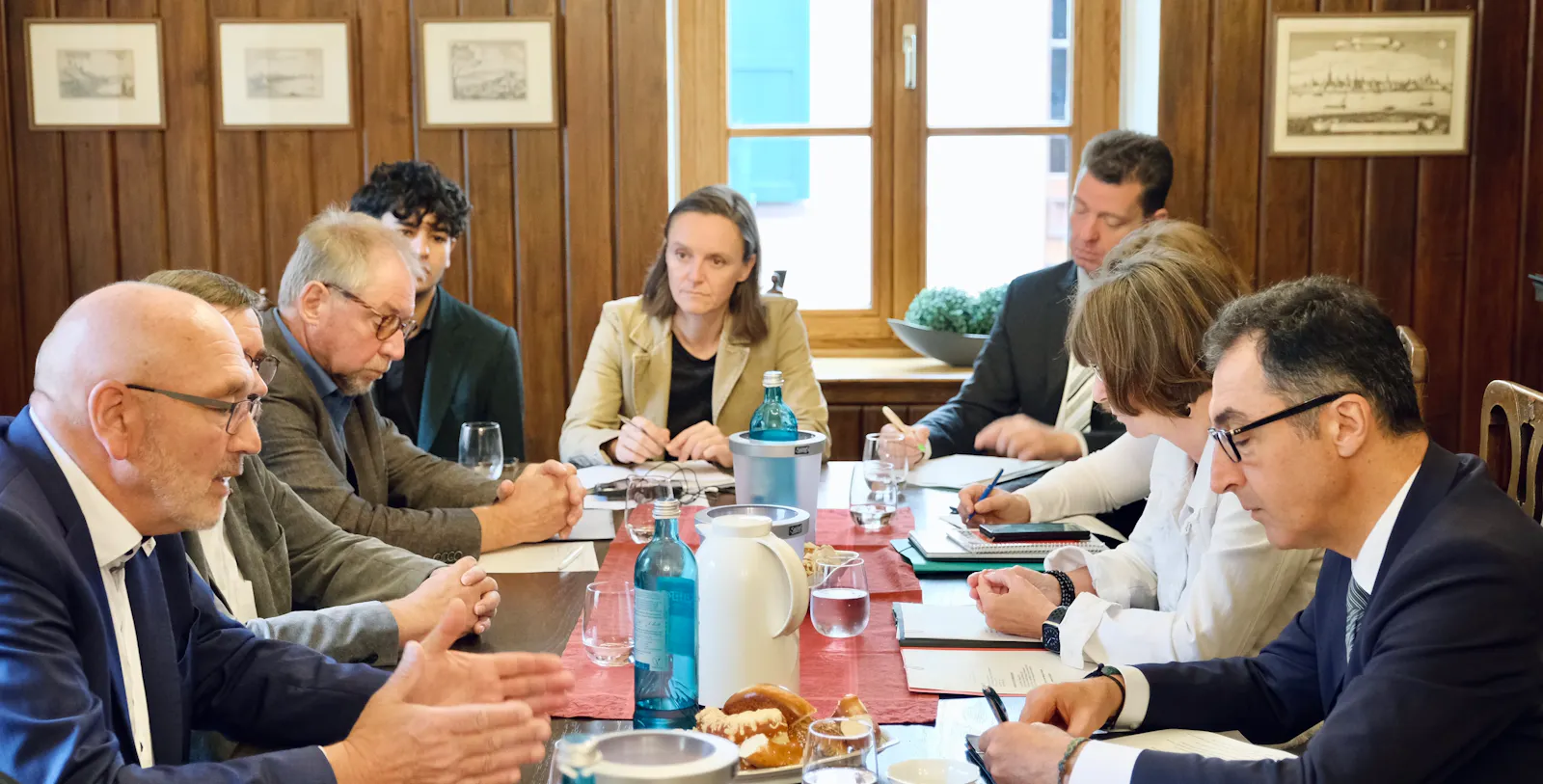 Männer und Frauen sitzen an einem Tisch und diskutieren