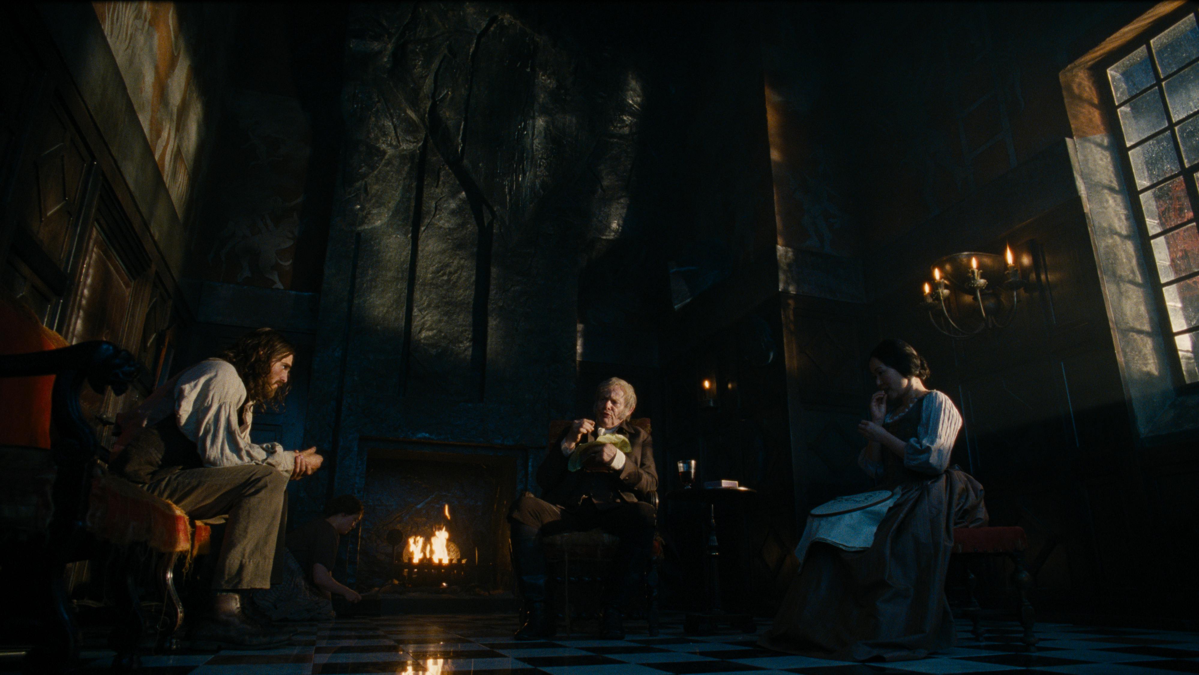 Luftig bis düster: In Wuthering Heights ist Mr. Earnshaw (Martin Clunes, M.) "Mann des Hauses", Heathcliff (Jacob Elordi, li.) und Nelly Dean (Hong Chau) sind Nutzgut // © 2026 Warner Bros. Ent. All Rights Reserved