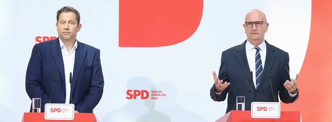 Lars Klingbeil und Dietmar Woidke stehen an Rednerpulten und geben eine Pressekonferenz. Im Hintergrund ist groß der SPD-Schriftzug zu sehen.