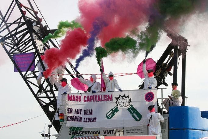 Protest von Ende Gelände, Besetzung eines Baggers, Transparent: smash capitalism, her mit dem schönen Leben
Menschen ins weißen Maleranzügen, bunter Rauch