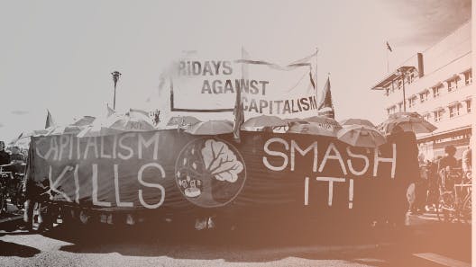 schwarz-weiß Foto, Frontbanner einer Demonstration, Text: capitalism kills, smash it