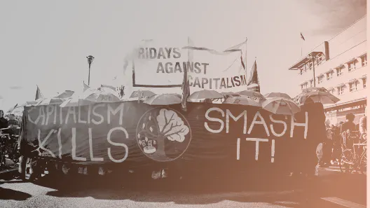 schwarz-weiß Foto, Frontbanner einer Demonstration, Text: capitalism kills, smash it