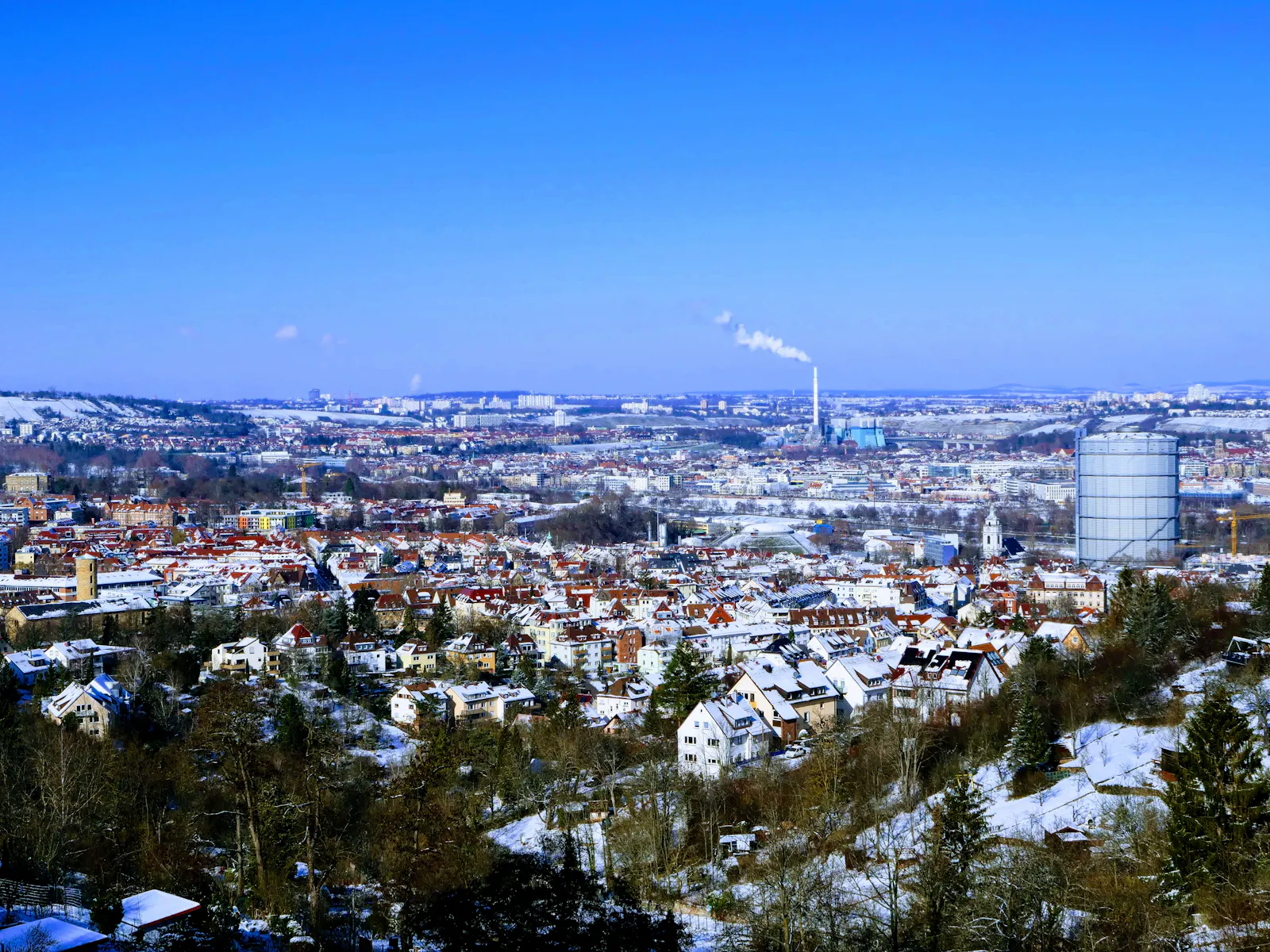 Ein in Zeiten des menschengemachten Klimawandels eher selten gewordenes Bild: Ein bisschen Schnee über Stuttgart-Ost und dem Kraftwerk Münster im Hintergrund. Foto: Jürgen Brand