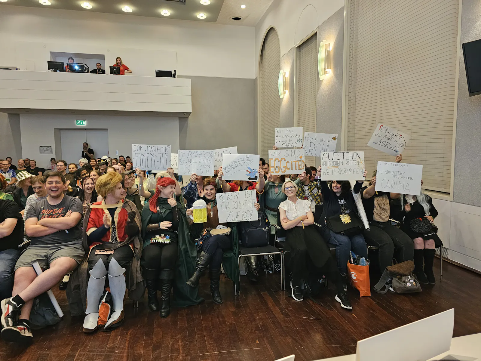 Das Publikum hält Schilder mit Anfeuerungen hoch.