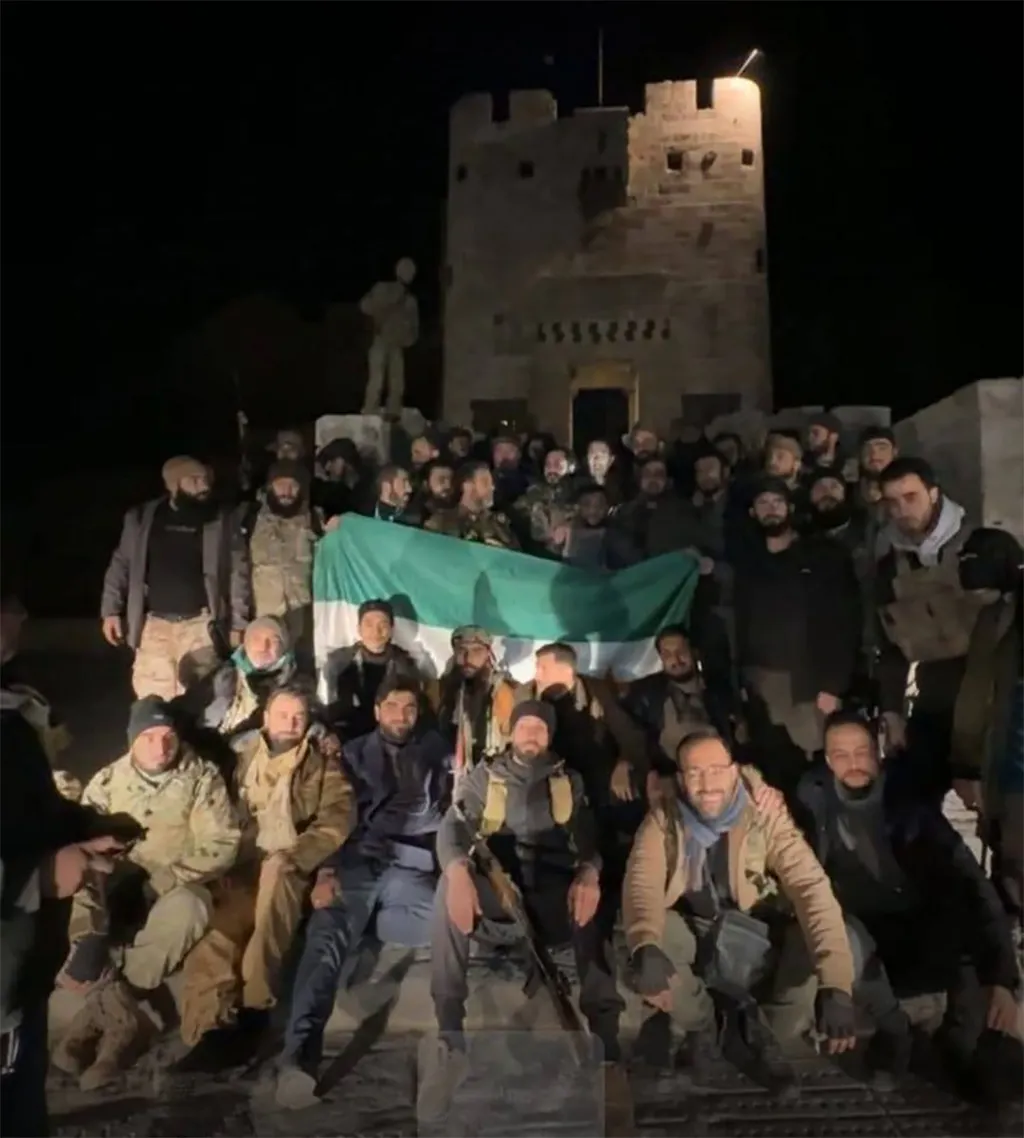 Posierende Kämpfer mit der syrischen Flagge vor der Zitadelle von Aleppo