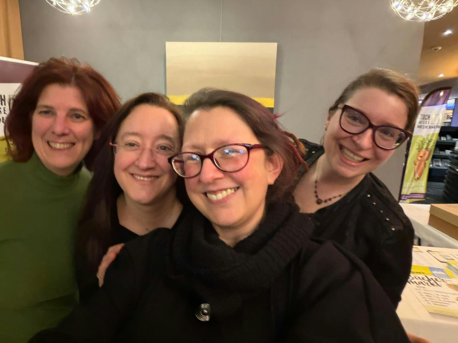 vier Frauen, die in die Kamera lächeln