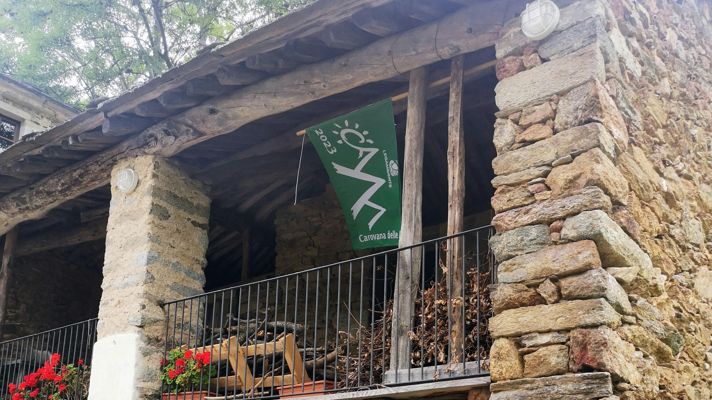 Edificio in pietra con appesa Bandiera verde 2023 di Legambiente