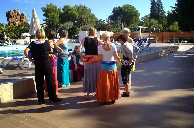 Frauen in Röcken am Pool. Tanzpause.