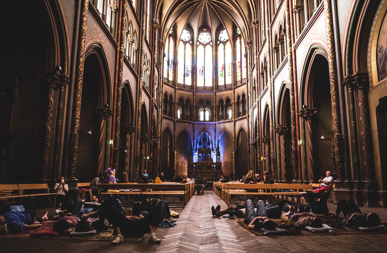 Menschen liegen auf Teppichen in der Église du Gésu in Toulouse, bei der Aufführung von "Solarium" von Maxime Denuc