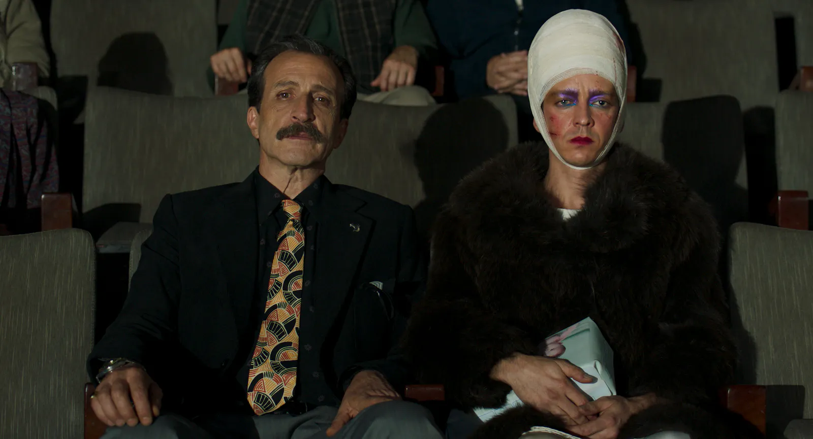 v. l. Sirena (Daniel Giménez Cacho) und Remo/Dolores (Nahuel Pérez Biscayart) sitzen im Publikum einer Pferdeauktion // © Rei Pictures