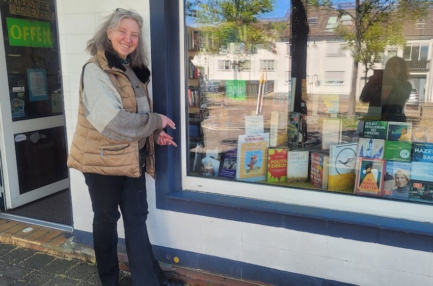 Buchhändlerin Verena Groß vor dem Schaufenster ihrer Bücherstube in Aegidienberg, in dem das Buch "17 JAHRE DEMENZ – So long, liebe Mama" von Christine Piontek ausliegt