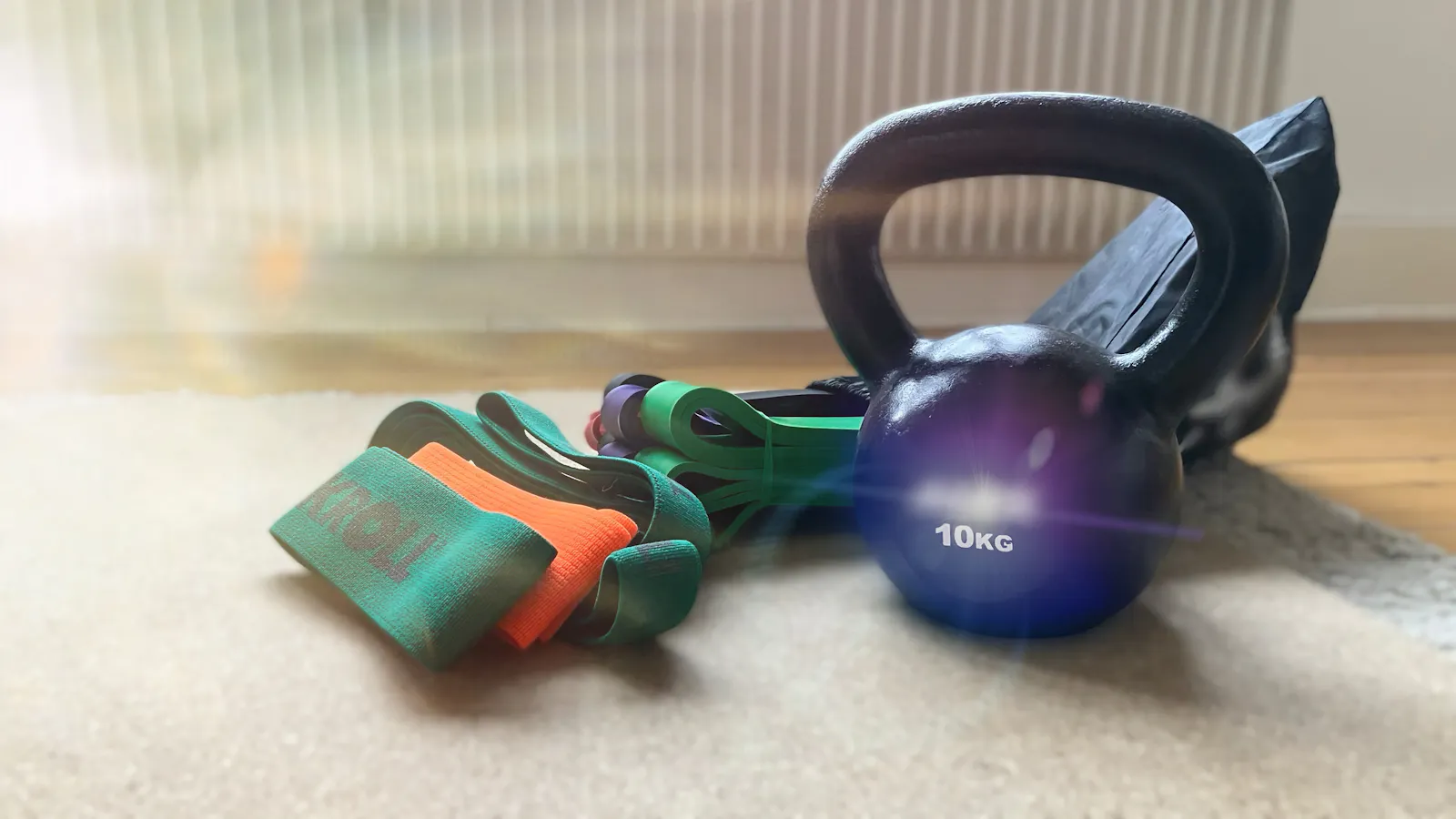 Fitnessbänder und Kettlebell auf einer Yogamatte aus Kork.