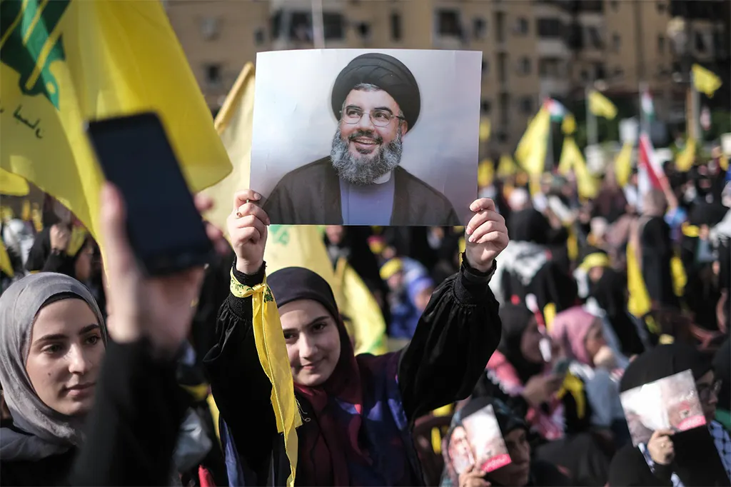 Junge Frau hält auf einer Kundgebung der Hosbollah in Beirut ein Bild von Nasrallah hoch.