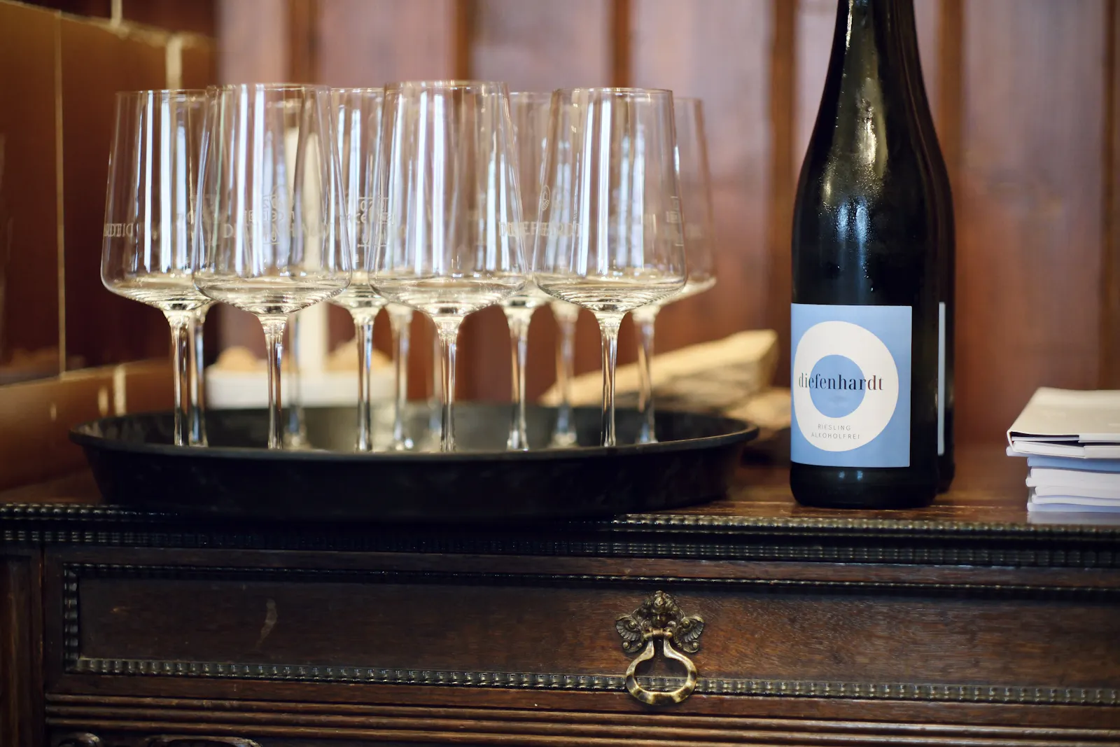 Mit Weißwein gefüllte Weingläser stehen auf einem Schrank.