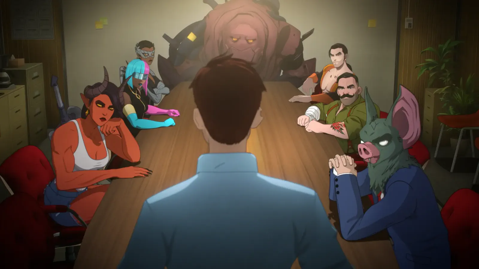 Screenshot from Dispatch, Robert standing in front of his team at a long table