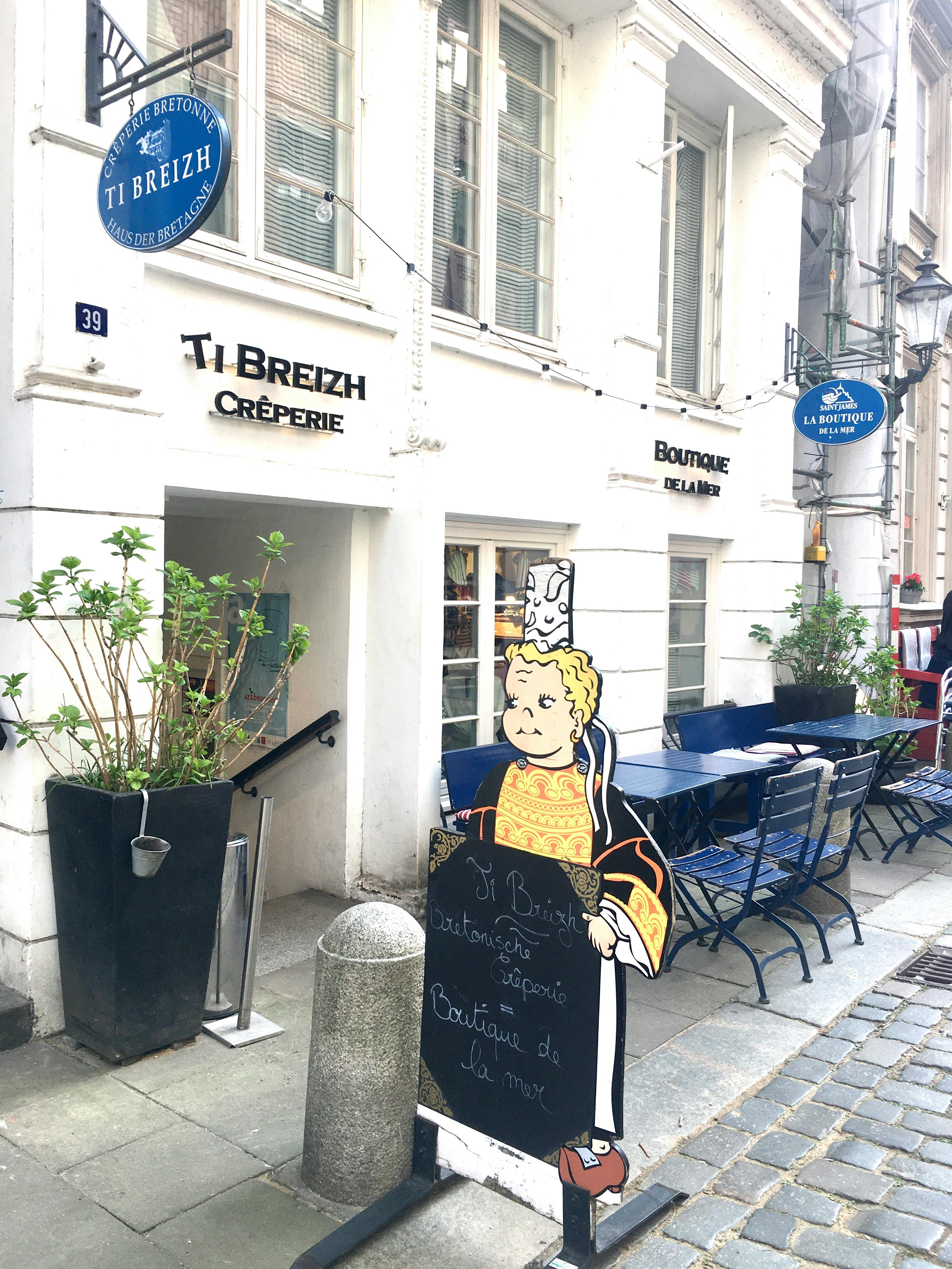 Haus Ti Breizh mit Schildern, Tischen und Stühlen