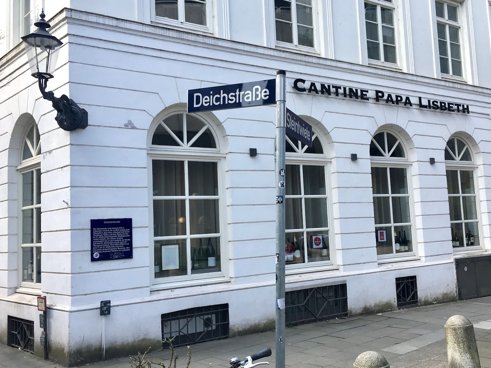 Straßenschild Deichstraße und weißes Haus mit der Aufschrift Cantine Papa Lisbeth