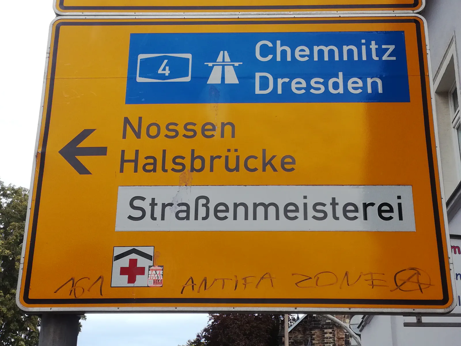 Straßenschild in Freiberg mit Anzeige Autobahn A4 Chemnitz Dresden sowie Nossen und Halsbrücke. Darunter Graffiti: 161 Antifa Zone