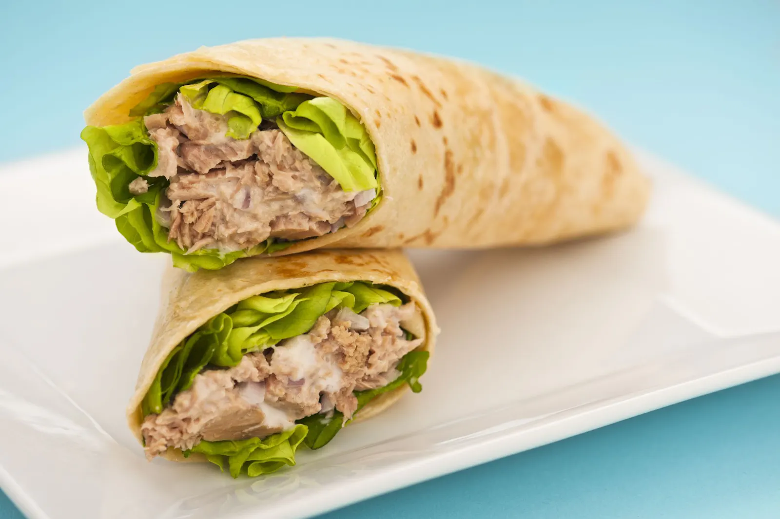 Das sind Thunfisch-Wraps, die auf einem Teller hübsch angerichtet worden sind.