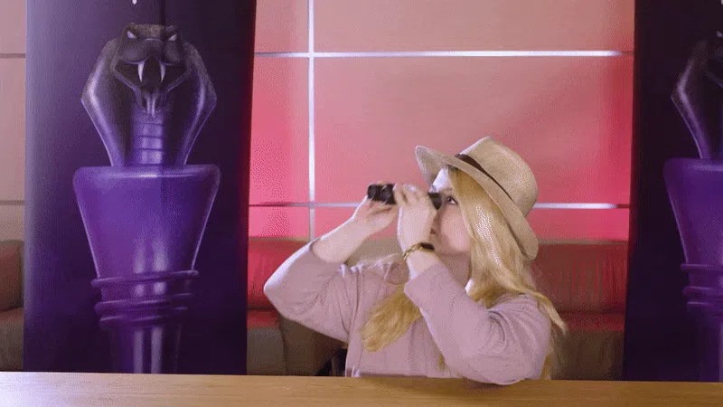 Eine Gif-Datei: Rieke hat einen Hut auf und guckt durch ein Fernglas. Hinter ihr schleicht sich Carina lang.