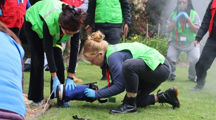 People wearing high-visibility vests during a practical disaster response training exercise