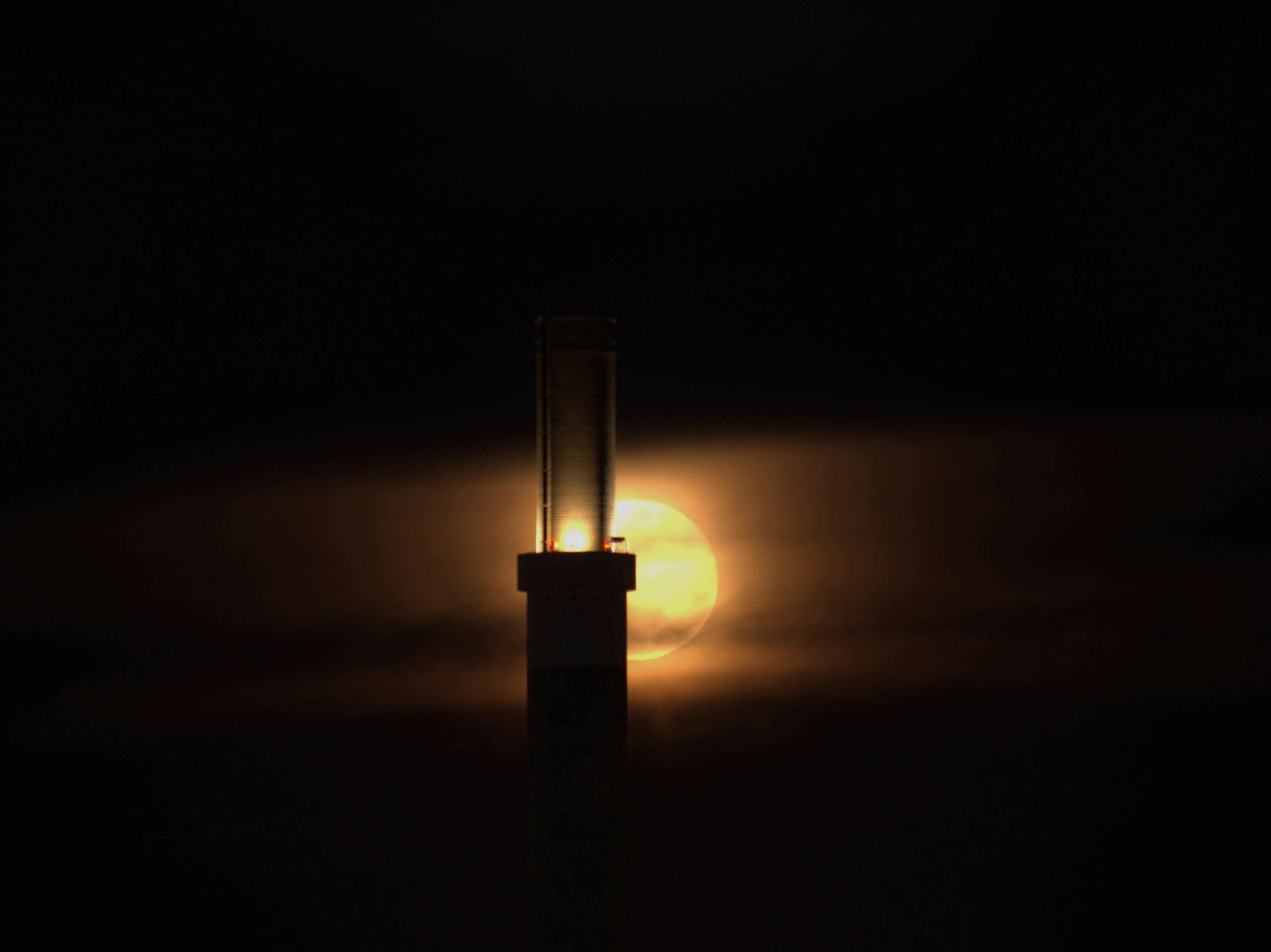 An den vergangenen Abenden war der Mond in Verbindung mit dem Saharastaub in der Atmosphäre immer wieder besonders spektakulär. Hier direkt hinter dem Kamin des alten Kraftwerks Gaisburg. Foto: Jürgen Brand