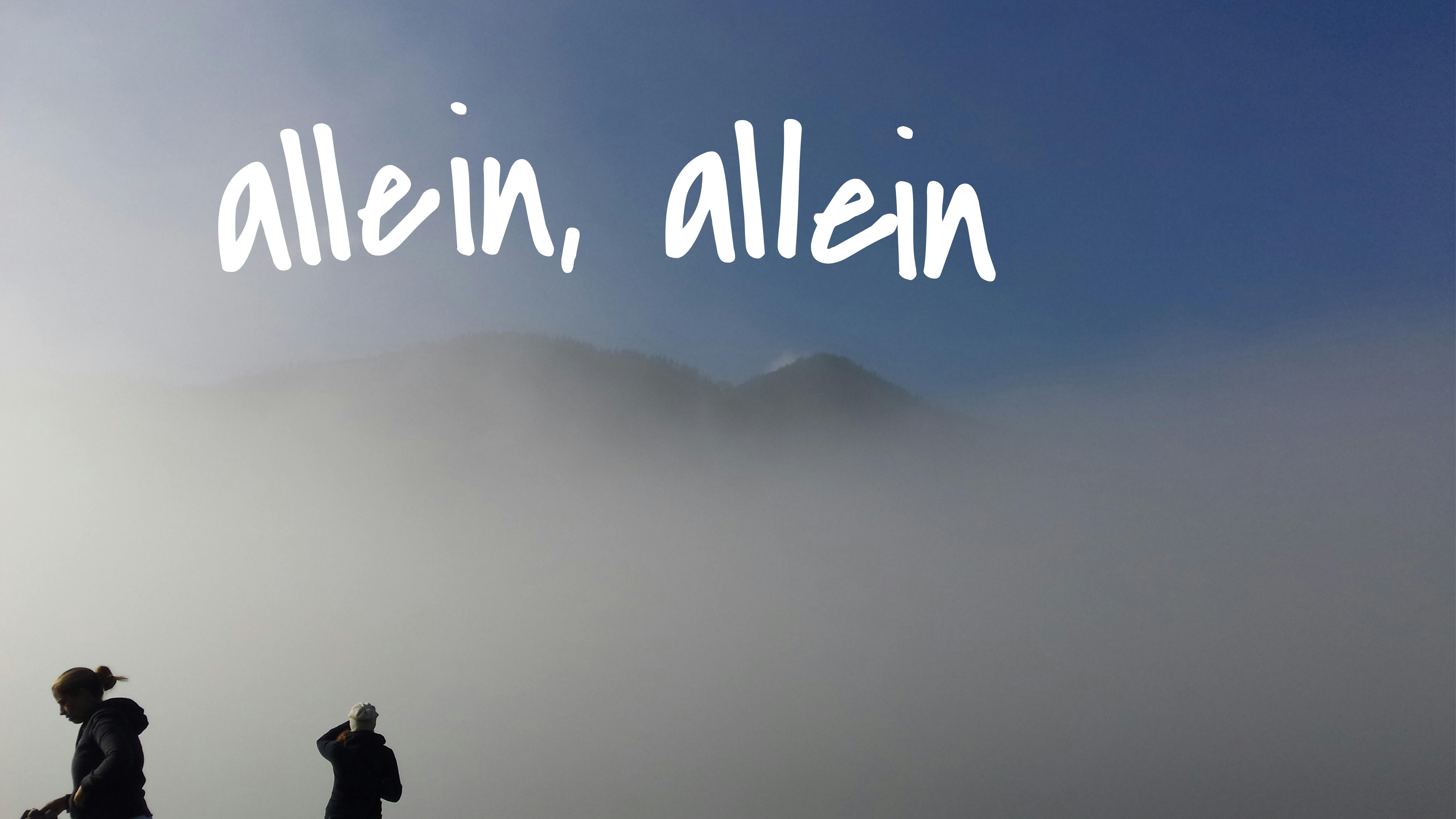 Ein Mann und eine Frau vor einem Berg, der im Nebel kaum zu sehen ist