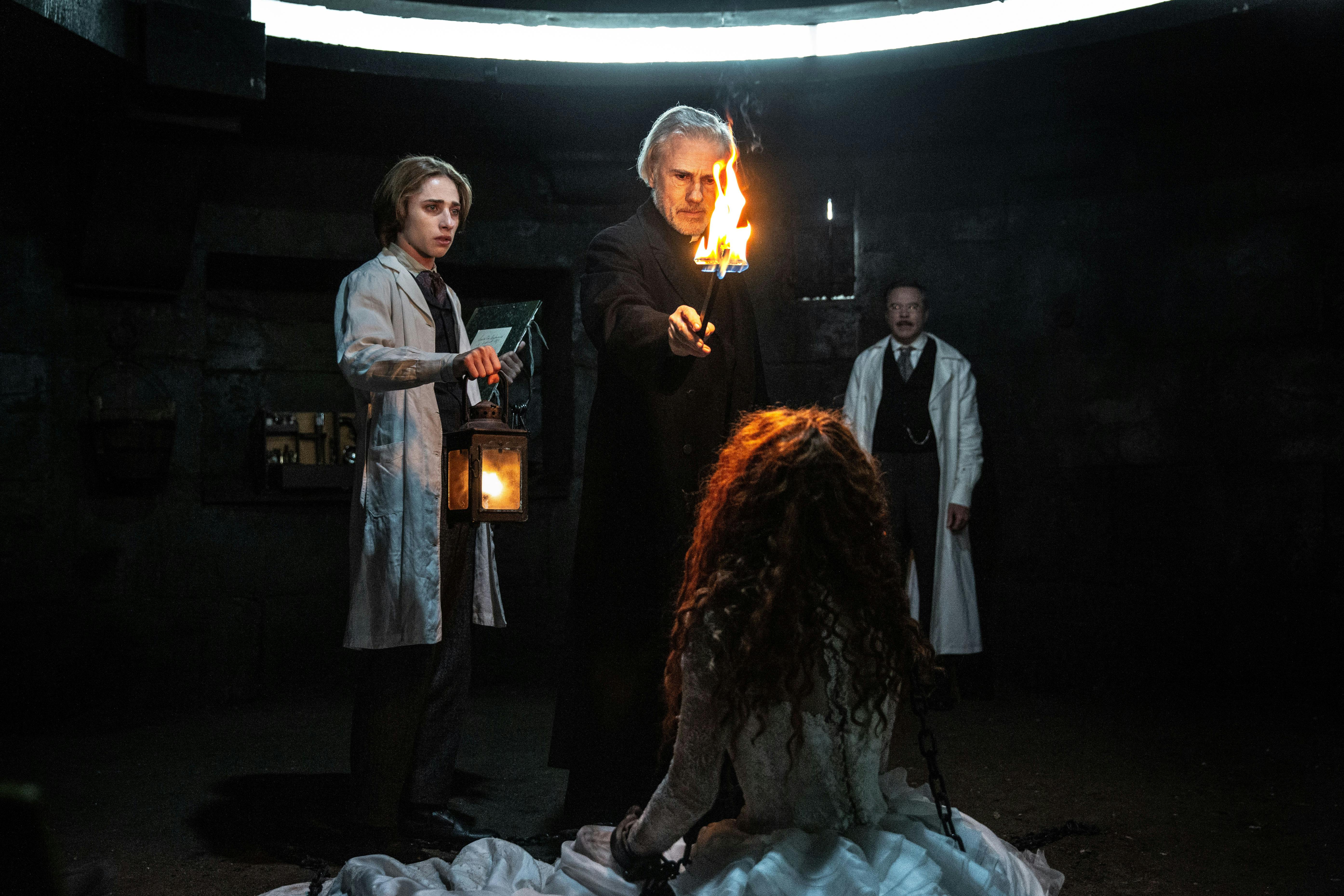 Der Assistent Simon (Raphael Luce), der Priester (Christoph Waltz) und Doktor Dumont (Guillaume de Tonquédec) mit Vampirin Maria (Matilda De Angelis) // © PHOTO SHANNA BESSON © 2025 LBP - EUROPACORP - TF1 FILMS PRODUCTION - SND/ LEONINE Studios