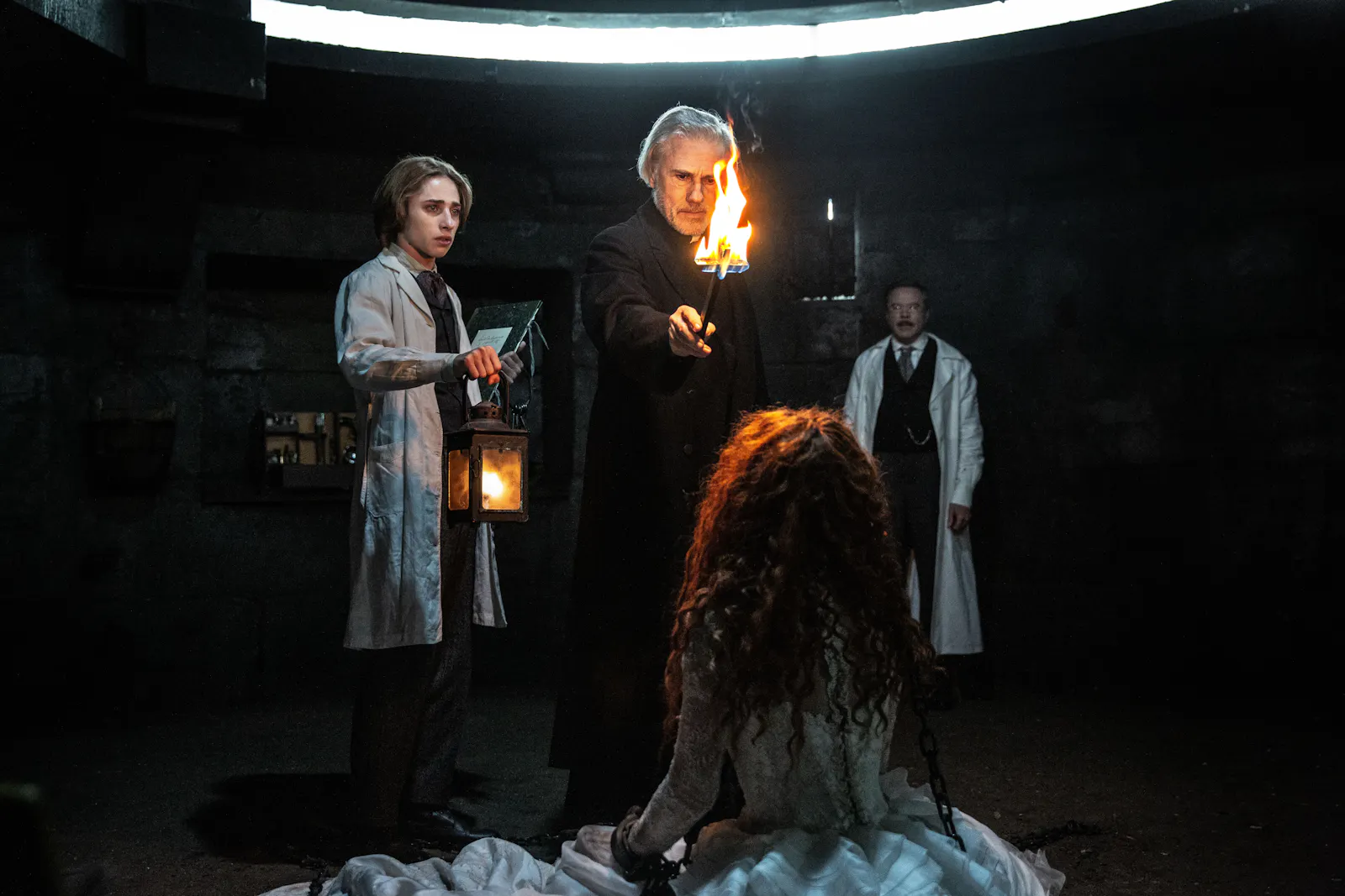 Der Assistent Simon (Raphael Luce), der Priester (Christoph Waltz) und Doktor Dumont (Guillaume de Tonquédec) mit Vampirin Maria (Matilda De Angelis) // © PHOTO SHANNA BESSON © 2025 LBP - EUROPACORP - TF1 FILMS PRODUCTION - SND/ LEONINE Studios