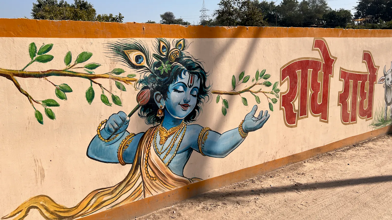 wall art in Vrindavan showing Krishna and the words "Radhe Radhe"