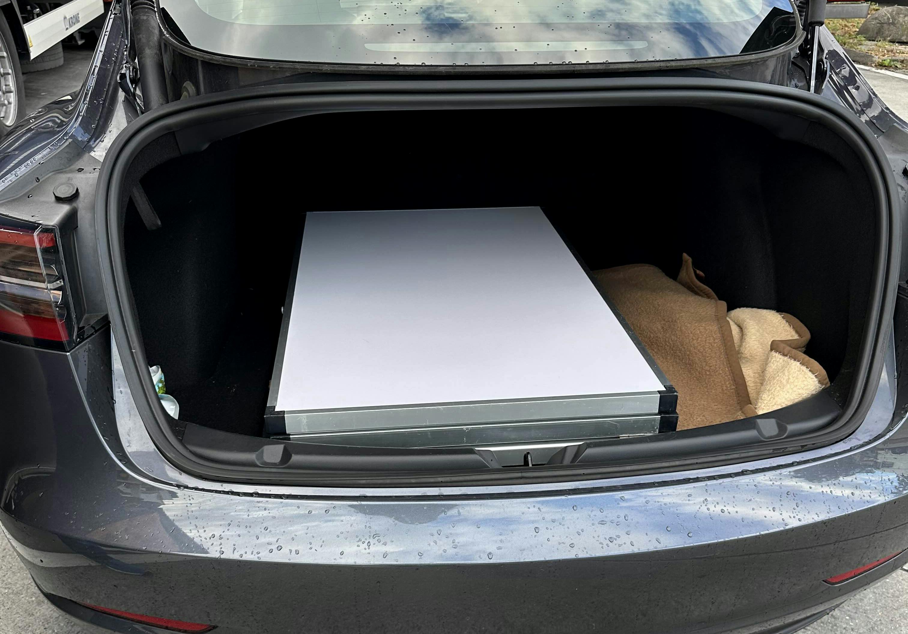 Zusammengeklappter Tapeziertisch im Kofferraum eines Autos.