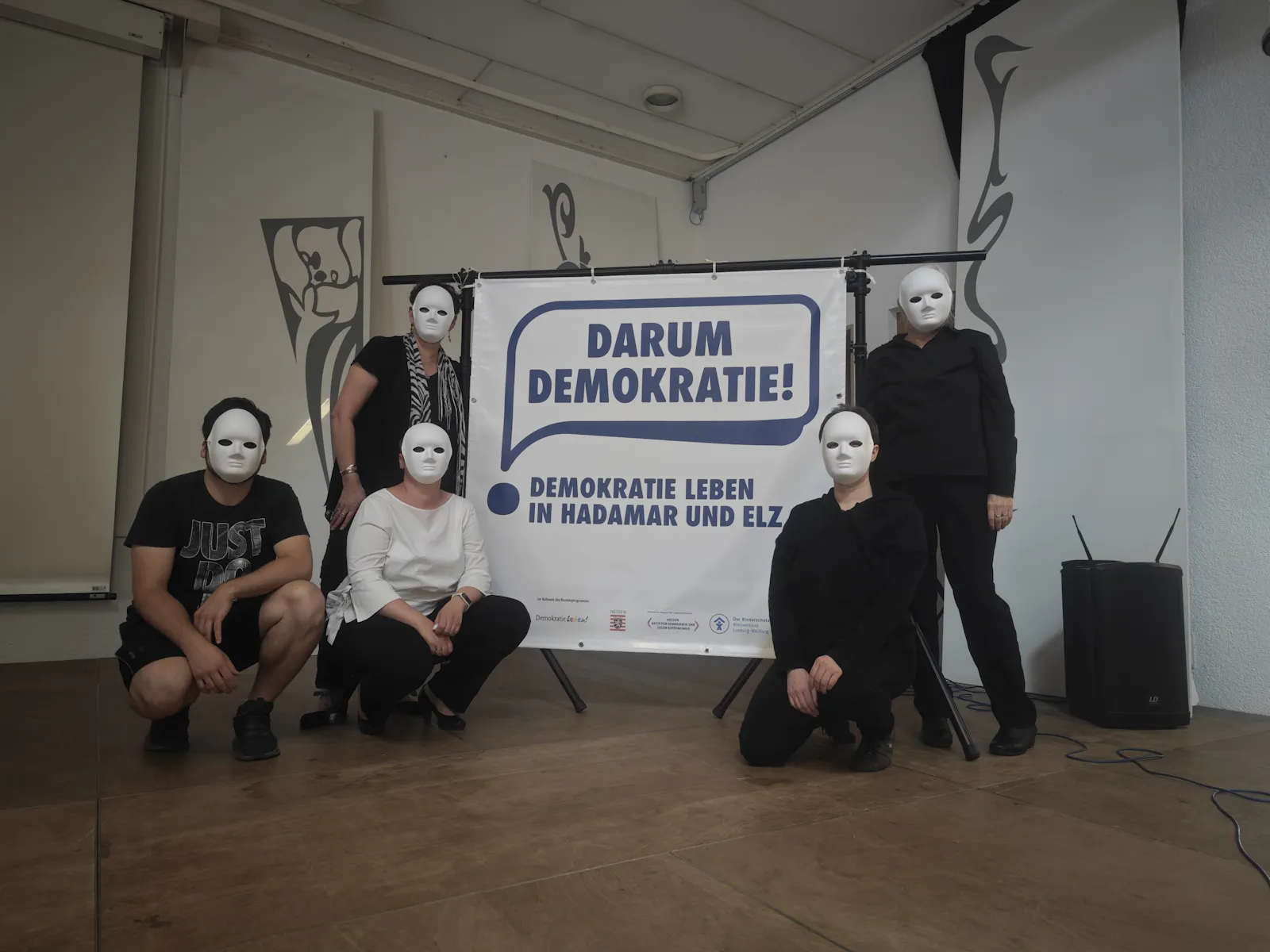 Auf dem Foto seht ihr fünf Personen mit weißen Masken
