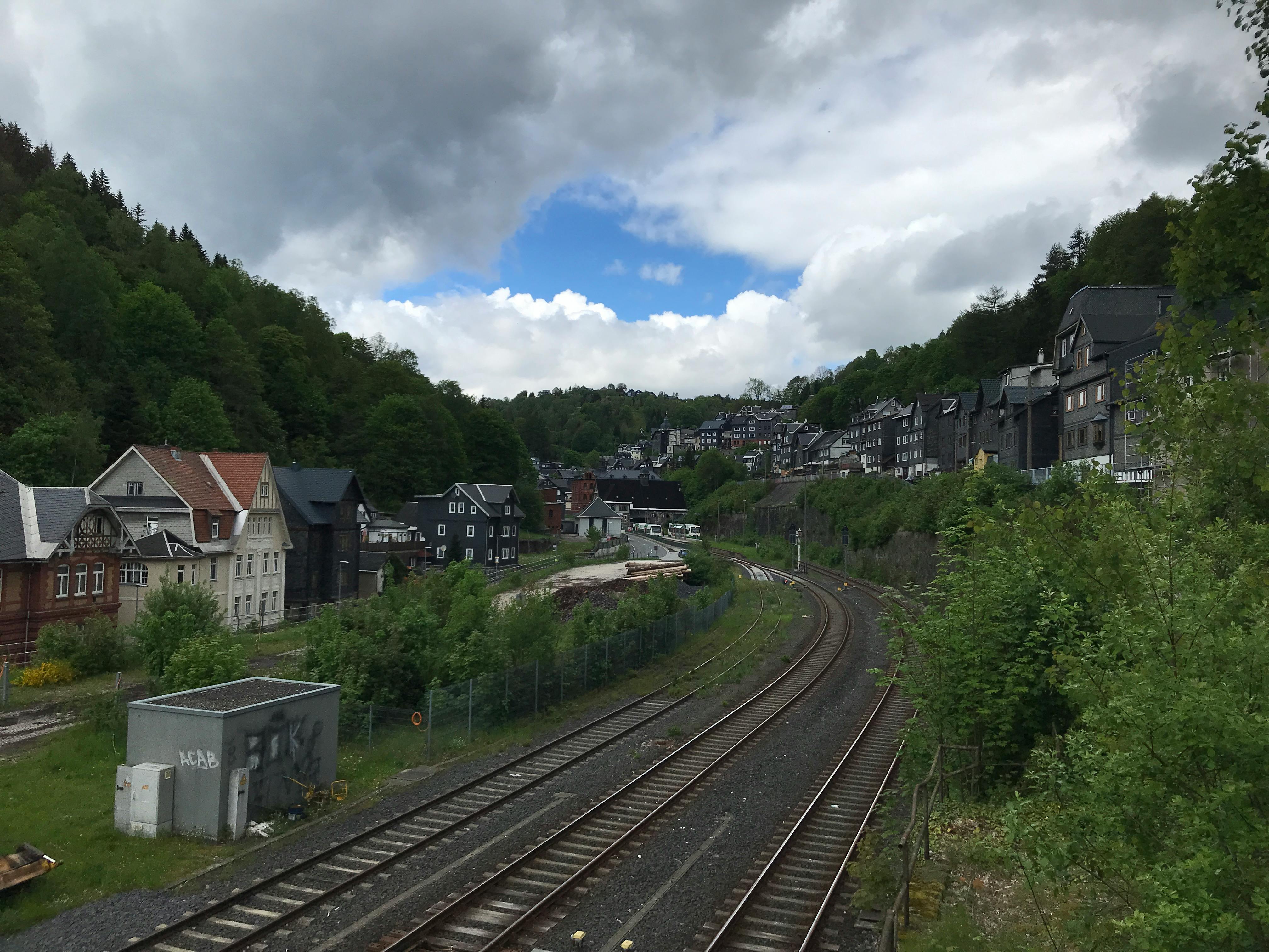 Schienennetz zum Bahnhof Lauscha. Links und rechts Wohnhäuser.
