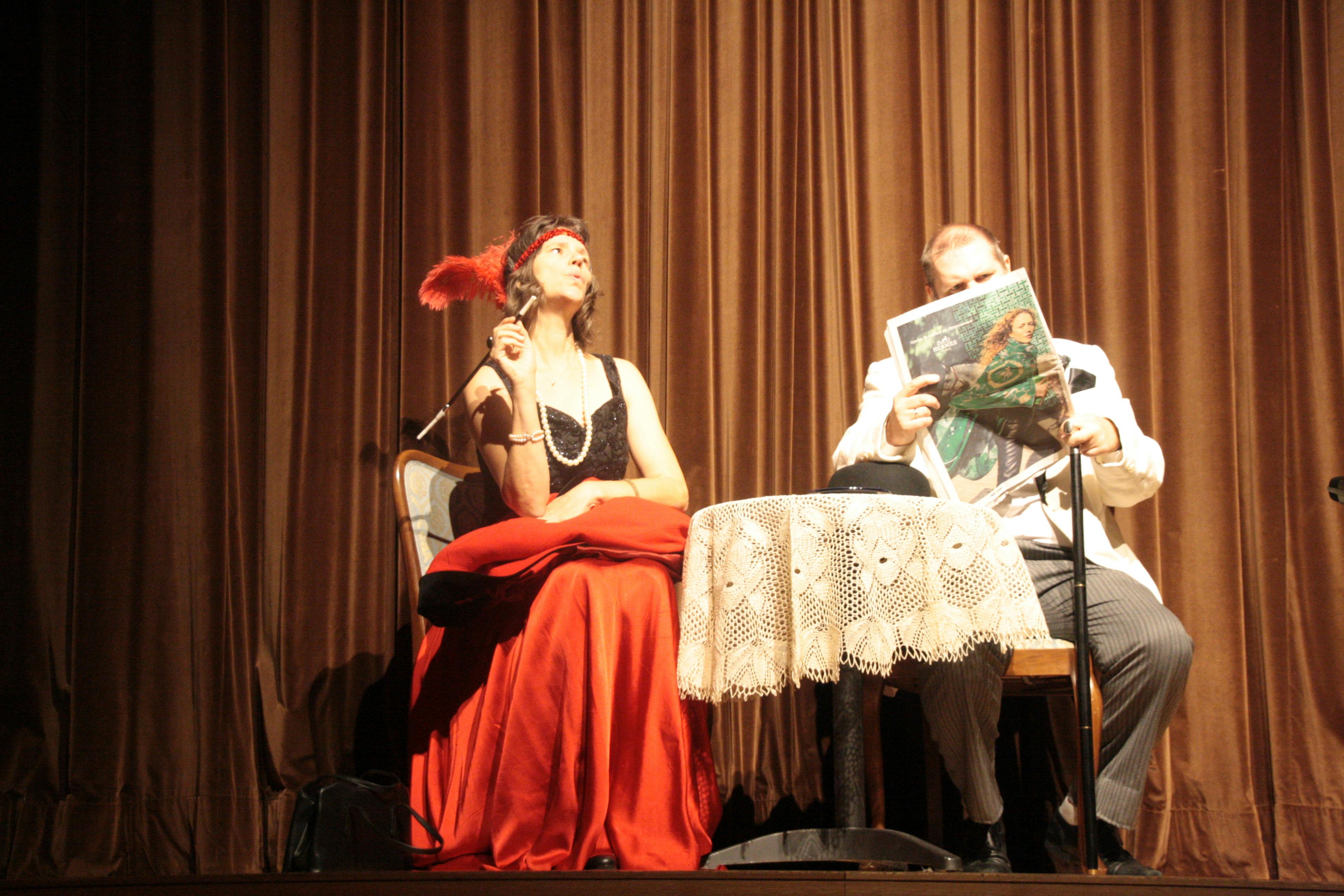 Auf dem Bild sehr ihr links eine rauchende Frau und rechts einen zeitungslesenden Mann aus einem Theaterstück