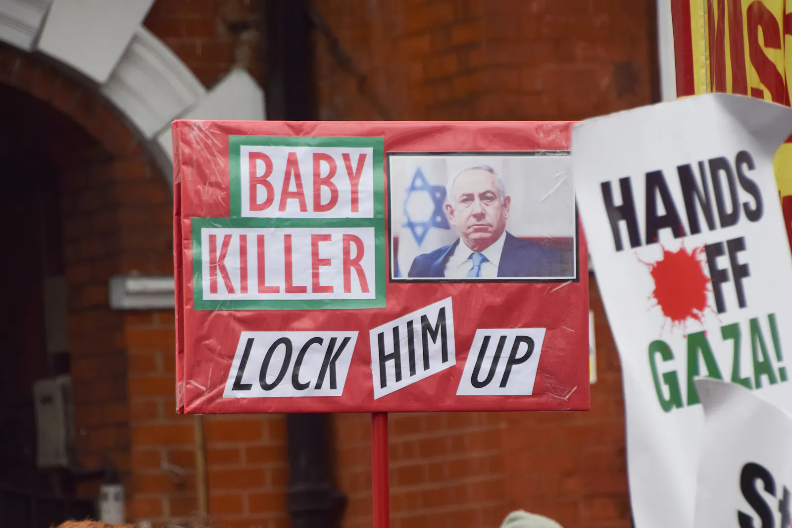 Ein Schild zeigt "Baby Killer" neben dem Bild von Netanjahu.