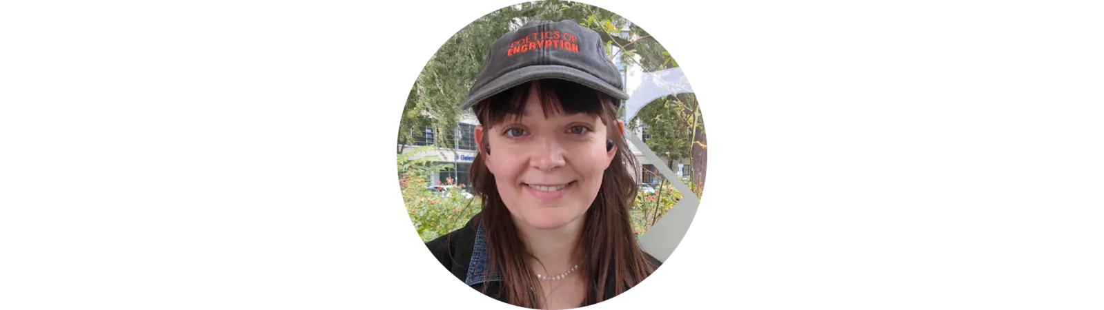 Auf dem Bild ist Natalie Sablowski zu sehen, ehrenamtliche Co-Vorstandsvorsitzende der Neuen deutschen Medienmacher*innen. Sie hat braune Haare, einen Pony und trägt eine Kappe.