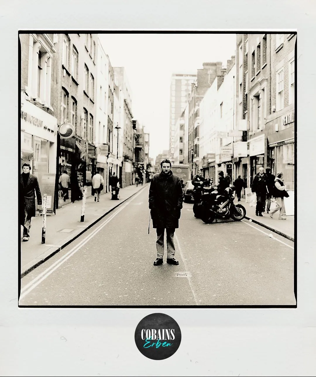 Zu sehen ist der Fotograf Jörg Steinmetz. Er steht mit den Händen in den Manteltaschen in der Berwick Street in London, der Straße, in der auch Oasis das Foto des Albumcovers von 'Morning Story' geschossen haben.
