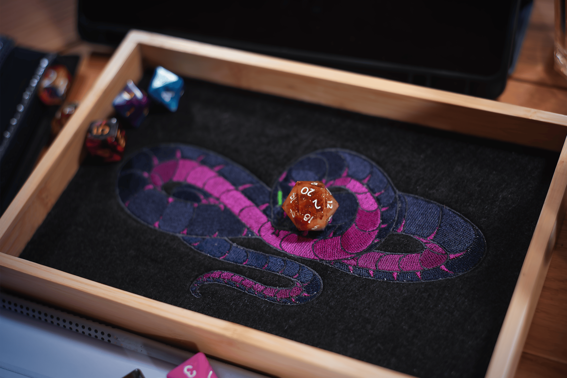 Patzes Dice Tray der verhüllten Schlange. Darin liegt ein W20, der eine natürliche 20 anzeigt. Genau die 20, die er in der letzten Episode geworfen hat, nachdem er sein Gebet in den Himmel brüllte.