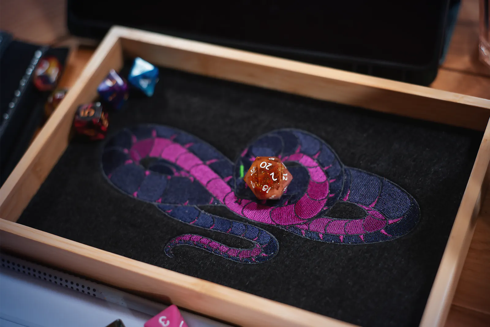 Patzes Dice Tray der verhüllten Schlange. Darin liegt ein W20, der eine natürliche 20 anzeigt. Genau die 20, die er in der letzten Episode geworfen hat, nachdem er sein Gebet in den Himmel brüllte.