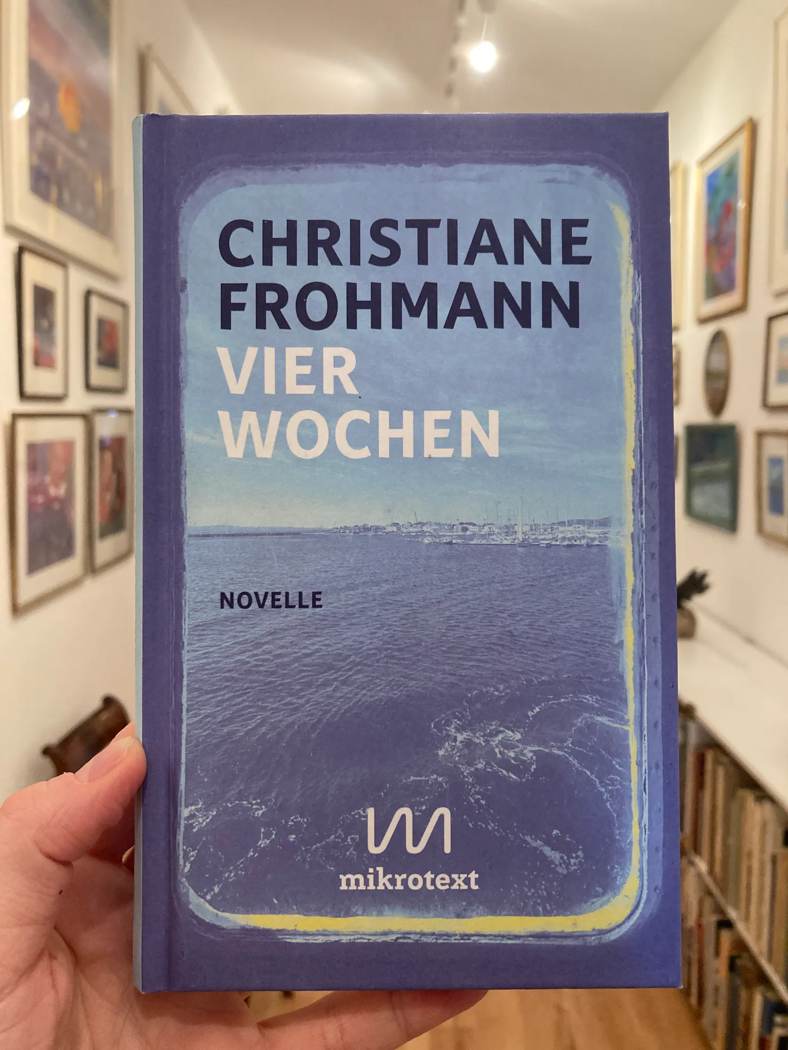 Das Cover der Novelle "Vier Wochen" von Christiane Frohmann. Das Motiv ist das Foto eines Hafens mit einem lichtblauen Filter unterlegt.