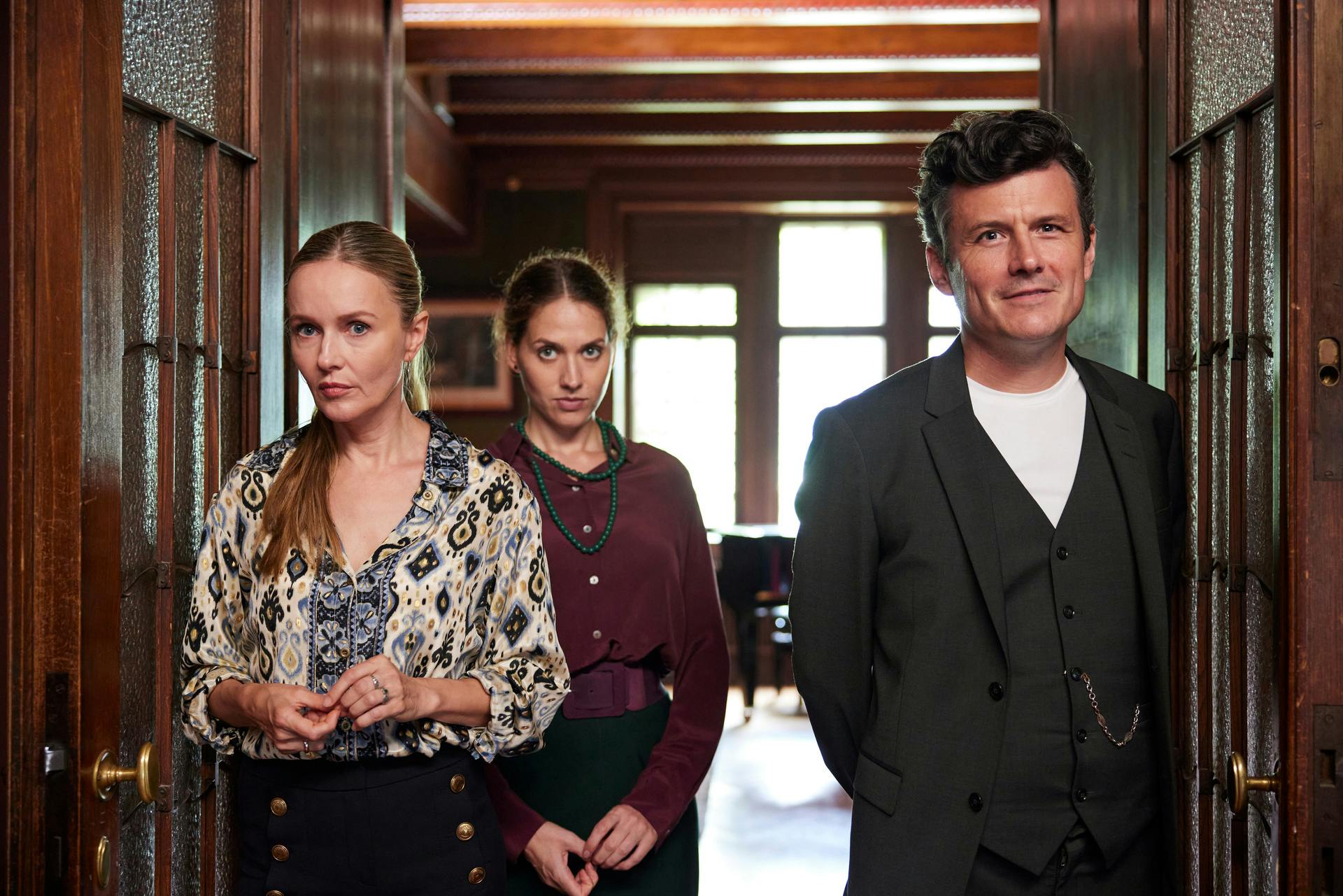 "Mama ist die Best(i)e Teil I": Argwöhnisch beobachtend stehen Stella (Stefanie Stappenbeck), Leonie (Fanny Krausz) und ihr Bruder  Severin (Manuel Rubey) in einer Doppelflügeltür.