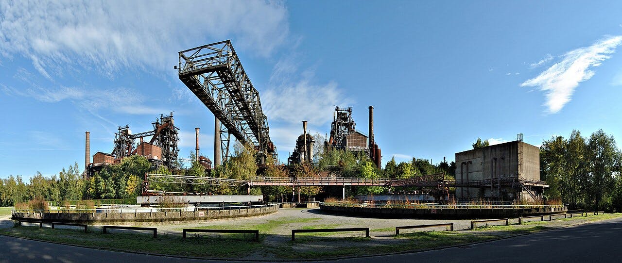 Panorama-Ansicht des Landschaftspark Nord Duisburg- Meiderich, einem alten Stahlwerk, dessen verlassene Bauten vor blauen Himmel zu sehen sind.