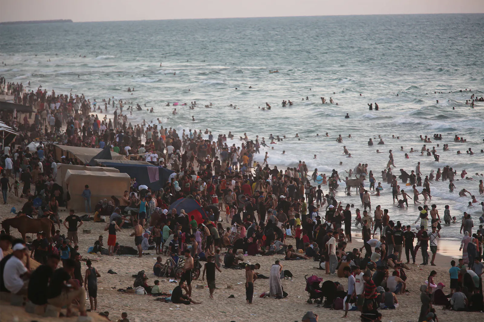Ein prall gefüllter Stand mit vielen hundert Menschen, viele planschen im Wasser.
