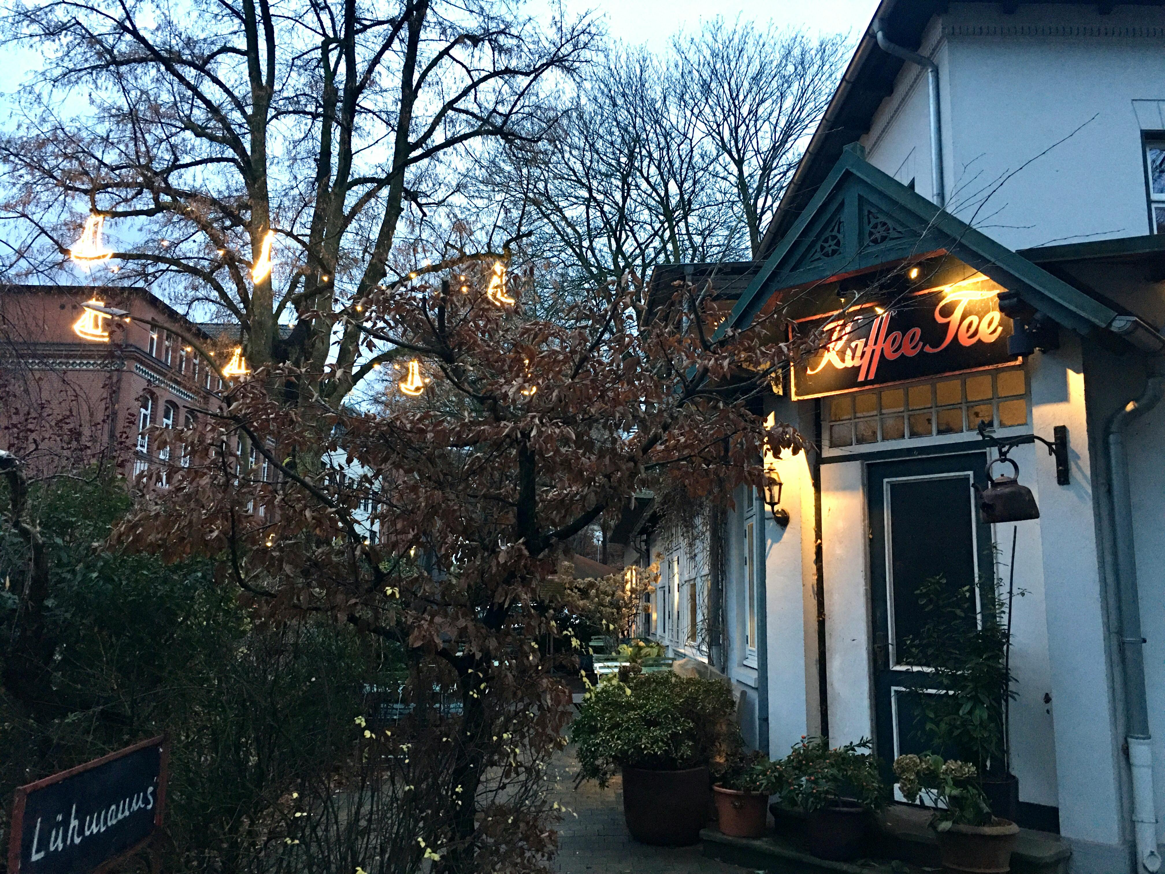 Ein Café mit der Aufschrift "Kaffee und Tee", dazu Weihnachtsbeleuchtung