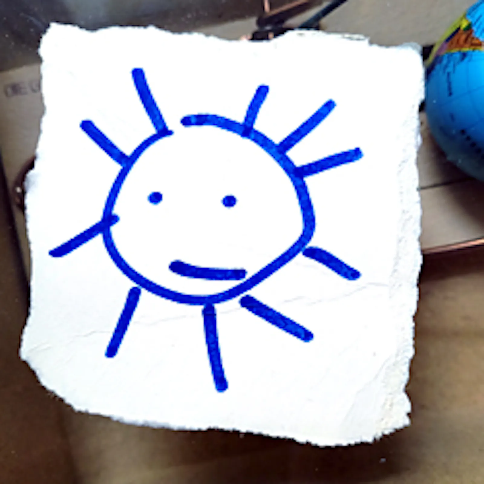 mit blauem Filzstift gezeichnete Sonne mit Gesicht