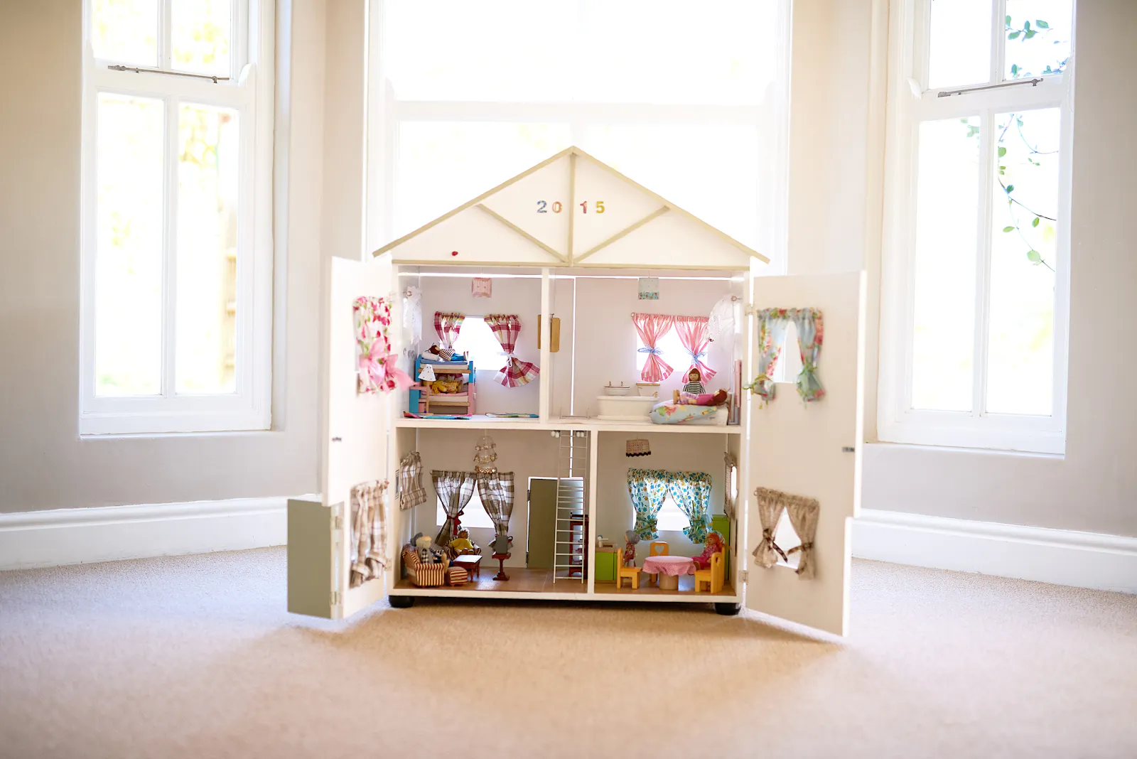 Ein aufwendig eingerichtetes Puppenhaus in einem Raum.