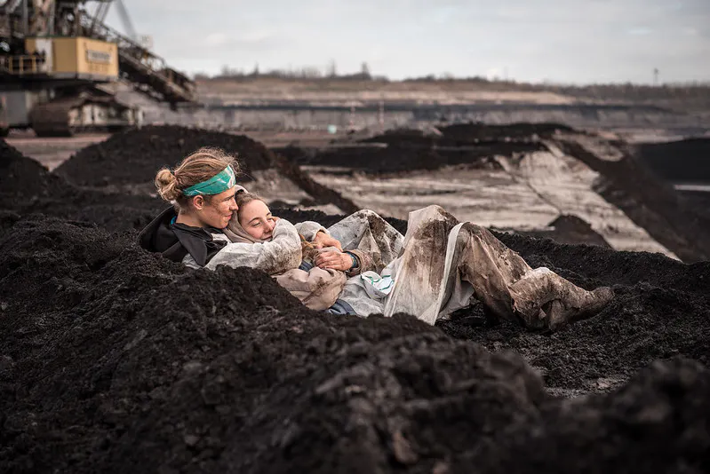 activists sharing a quiet moment in an open coal pit mine
EG mass action