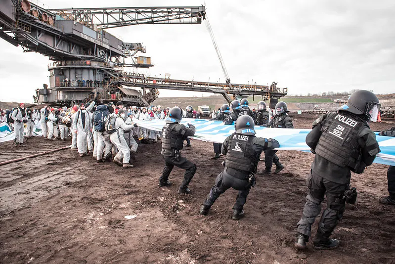 EG activists struggling with police in front of a digger